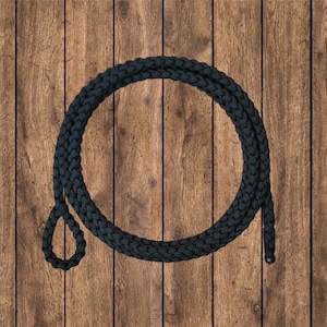 May include: A black braided rope with a loop at one end. The rope is coiled on a wooden surface.