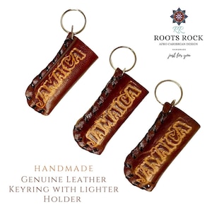 May include: Three brown leather keychains with a lighter holder. Each keychain has the word "Jamaica" embossed in gold lettering. The keychains are handmade and feature a stitched design.