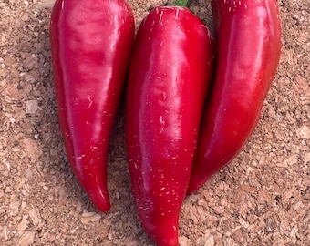 May include: Three vibrant red chili peppers with smooth, glossy skins and green stems. Each pepper has a tapered, elongated shape with subtle white striations on the surface, showcasing a fresh, firm texture and a deep, uniform crimson color.