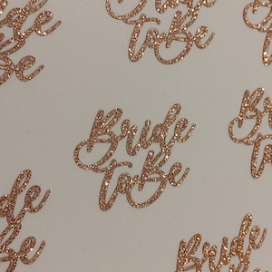 Könnte beinhalten: Sechs goldfarbene Glitzer-Ausschnitte mit der Aufschrift "Bride to Be". Die Ausschnitte eignen sich perfekt zum Dekorieren für eine Bridal Shower oder einen Junggesellinnenabschied.