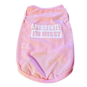 May include: Pink dog shirt with the text "Apparently I'm Messy" in white.