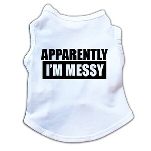 May include: White sleeveless dog shirt with black text that reads "APPARENTLY I'M MESSY".