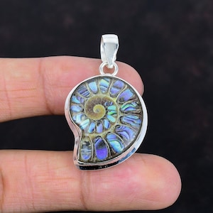 May include: A silver pendant featuring an iridescent ammonite fossil. The fossil displays a spiral pattern with shades of blue, green, and brown. The pendant has a polished silver bail for a necklace chain.