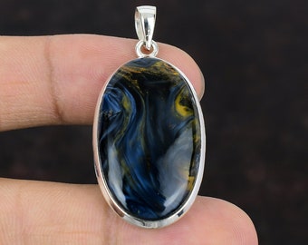 Puede incluir: Pendiente de plata con una piedra de ojo de tigre azul y oro de forma ovalada.