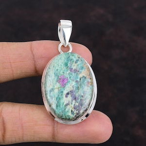 Può includere: Pendente di forma ovale con una pietra preziosa verde e rosa con accenti argentati. La pietra preziosa presenta un motivo screziato con inclusiones rosa e bianche.