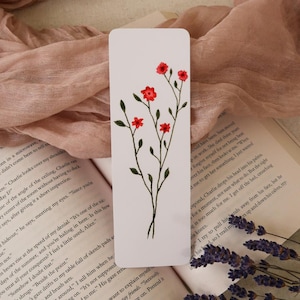 May include: White bookmark featuring a hand-drawn floral design. The illustration showcases a delicate stem with multiple small red flowers and green leaves. The bookmark is rectangular and ideal for books.