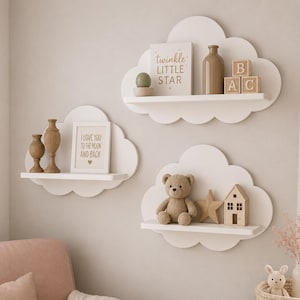 Peut inclure: Trois &eacute;tag&egrave;res murales blanches en forme de nuage. L'&eacute;tag&egrave;re sup&eacute;rieure contient un livre intitul&eacute; "twinkle LITTLE STAR", une bouteille marron et des cubes avec les lettres B, A, C. L'&eacute;tag&egrave;re de gauche porte deux vases marron et un cadre.