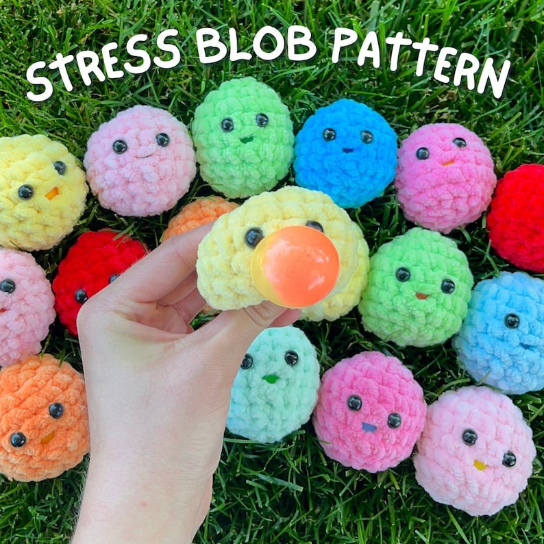 May include: A collection of colourful, crocheted stress balls with various facial expressions. The balls are made of soft, fuzzy yarn and are designed to be squeezed for stress relief. The text "Stress Blob Pattern" is written across the top of the image.