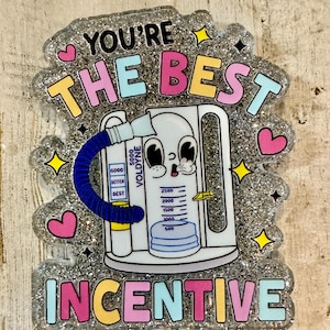 May include: A glittery badge with the words "YOU'RE THE BEST INCENTIVE" in colourful bubble letters. The design features a cartoon-style VOLDYNE device with a blue tube, pink hearts, and yellow stars. The device has a gauge with measurements.