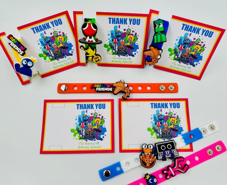 May include: Rainbow Friends themed party favors with colorful thank you cards, bracelets, and character charms. The cards feature a group of cartoon characters with the text "Thank You" and "For Making My Birthday Special!" The bracelets are made of silicone and have the Rainbow Friends logo. The charms are made of plastic and feature different characters from the game.