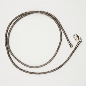 May include: A silver chain necklace with a lobster clasp closure.