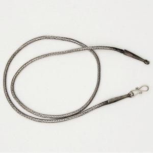 May include: A silver chain necklace with a braided design and a simple clasp.