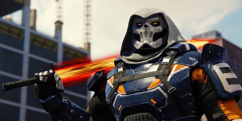 May include: A hooded figure wearing a blue and orange armored suit with a skull-like mask. The figure is holding a black weapon and a glowing orange blade is visible in the background.