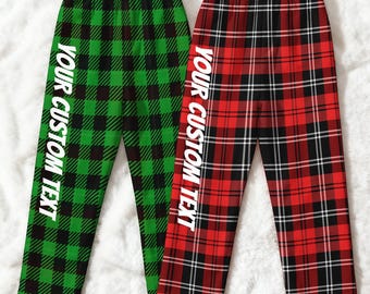 May include: Two pairs of pajama pants. One pair is green and black plaid, the other is red, black, and white plaid. Both have the text "YOUR CUSTOM TEXT" printed vertically in white.