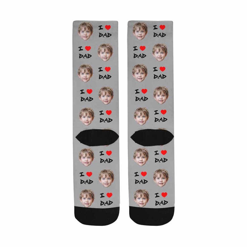 May include: A pair of gray socks with a repeated pattern of a child's face and the text "I love Dad" with a red heart.