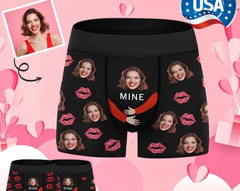 May include: Black boxer shorts with a repeated pattern of red lips and a woman's face. The text "MINE" is printed in red on the front of the boxers.