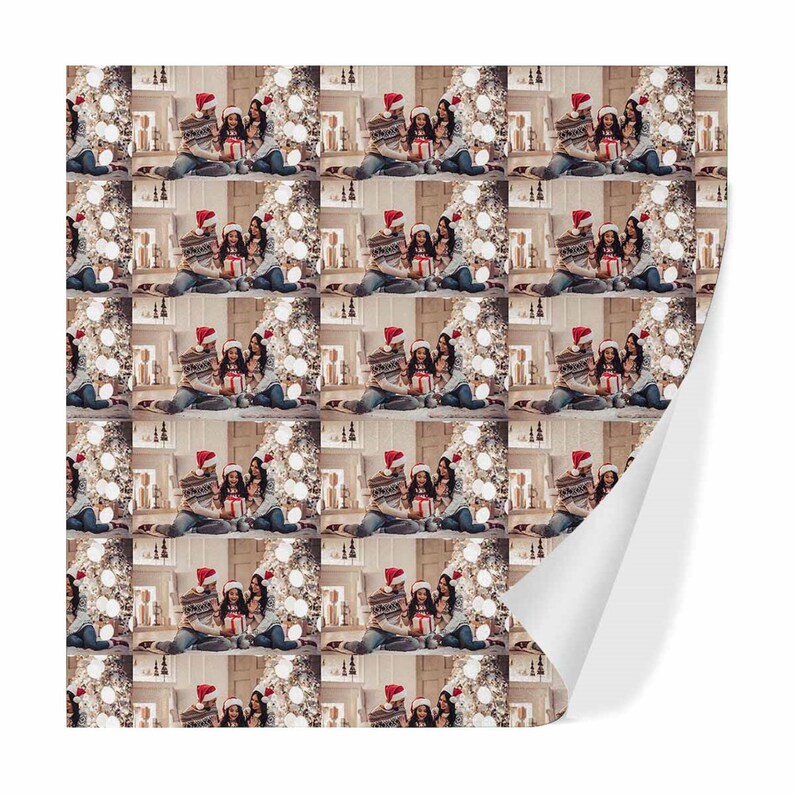 May include: A repeating pattern of a family of three opening Christmas presents in front of a decorated Christmas tree. The family are wearing Santa hats and smiling.