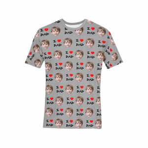 May include: A gray t-shirt with a repeating pattern of a child's face and the words "I love Dad" with a red heart.
