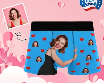 May include: Personalized boxer shorts with a blue background and a repeated pattern of red hearts and a woman's face. The woman's face is smiling and her hair is brown. The text "Personalized Boxers" is at the bottom of the image.
