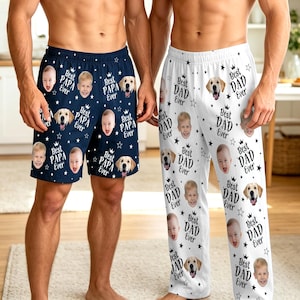 May include: Navy blue pajama shorts with a pattern of baby faces, golden retrievers, stars, and the text "Best PAPA Ever." White pajama pants with a similar pattern, featuring the text "Best DAD Ever."