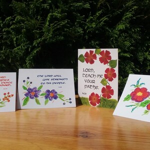 May include: Four handmade greeting cards with watercolor floral designs and inspirational quotes. The quotes are: "Great is the Lord who delights in the peace of his servant", "The Lord will give strength to his people", "Lord, teach me your paths", and "O Lord, how precious is your love".