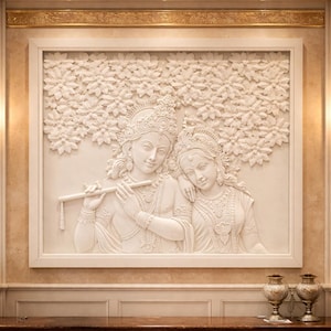 Op de afbeelding: Een wit reliëfbeeldhouwwerk van twee figuren, waarvan één een fluit bespeelt, in een omlijst paneel. De figuren dragen sierlijke sieraden en hoofdtooien. Het kunstwerk is gemonteerd op een muur met decoratieve lijsten en wandkandelaars.