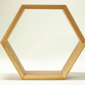 Op de afbeelding: Een zeshoekige houten plank met een natuurlijke houtkleur. De plank is gemaakt van massief hout en heeft een eenvoudig, modern ontwerp.