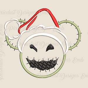 May include: Embroidered design of a green and white character wearing a red and white Santa hat. The character has a stitched smile and a zigzag pattern on its mouth.