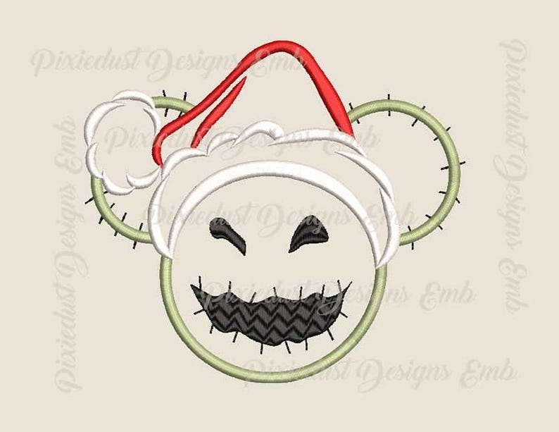 May include: Embroidered design of a green and white character wearing a red and white Santa hat. The character has a stitched smile and a zigzag pattern on its mouth.