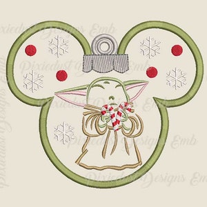 May include: Green Christmas bauble shaped like Mickey Mouse ears with a small green alien character holding candy canes in the centre. The bauble has red and white snowflakes and red dots around the edges.