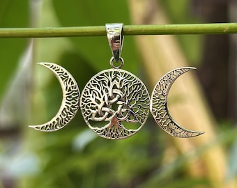 May include: Silver pendant featuring a triple moon design with a tree of life in the center. The pendant is made of sterling silver and has a detailed design.