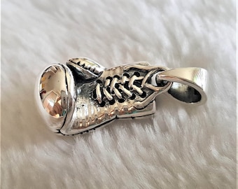 May include: A silver boxing glove pendant with a detailed design and a loop for attaching to a chain.