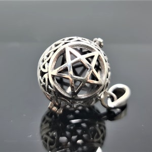 Peut inclure: Pendentif en argent avec un pentagramme à l'intérieur d'une sphère. La sphère est décorée d'un motif de nœud celtique.