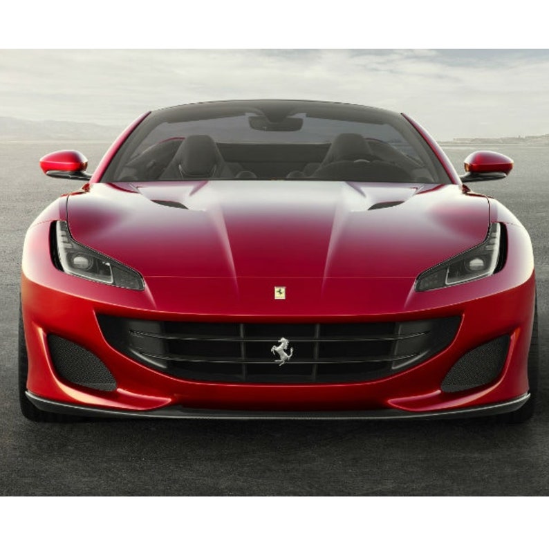 May include: A red Ferrari sports car with a black grille and a black front bumper. The car has a black interior and a black windshield.