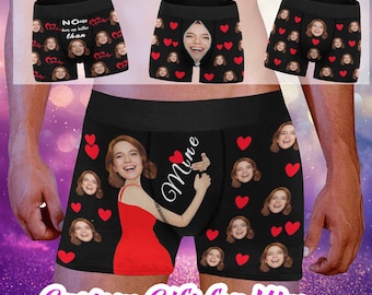 May include: Black boxer shorts with a repeated pattern of red hearts and a woman's face. The text "Mine" is written in white on the front of the shorts.