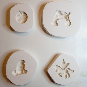 以下が含まれることがあります： 樹脂工芸品を作るための白いシリコンモールド4個。モールドは、ユニコーンの頭、翼のあるユニコーン、後ろ足で立っているユニコーン、座っているユニコーンなど、さまざまなユニコーンのデザインが特徴です。