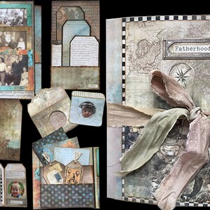 May include: A scrapbook with a brown leather cover and a map design. The cover is decorated with a compass, a ribbon, and the word "Fatherhood". The scrapbook is filled with photos and other memorabilia.