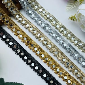 May include: Three strips of decorative trim featuring a repeating geometric lattice pattern embedded with small reflective mirror pieces. The trim is available in three distinct colors: a metallic silver, a metallic gold, and a solid black.
