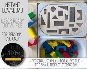 May include: A white tray with cutouts of various shapes, including circles, squares, rectangles, and triangles. A white bin filled with colorful wooden blocks is below the tray. The text "INSTANT DOWNLOAD", "LASER READY DIGITAL FILE", "FOR PERSONAL USE ONLY", and "::: PERSONAL USE ONLY ::: DIGITAL SVG FILE ::: FITS SMALL TROFAST STORAGE BIN" is visible in the image.