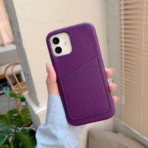 May include: Purple leather phone case with a built-in card holder.