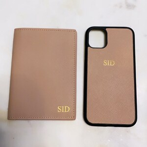 May include: Two matching personalized phone cases and a wallet in a light pink color with the name "SID" embroidered in gold on each item.