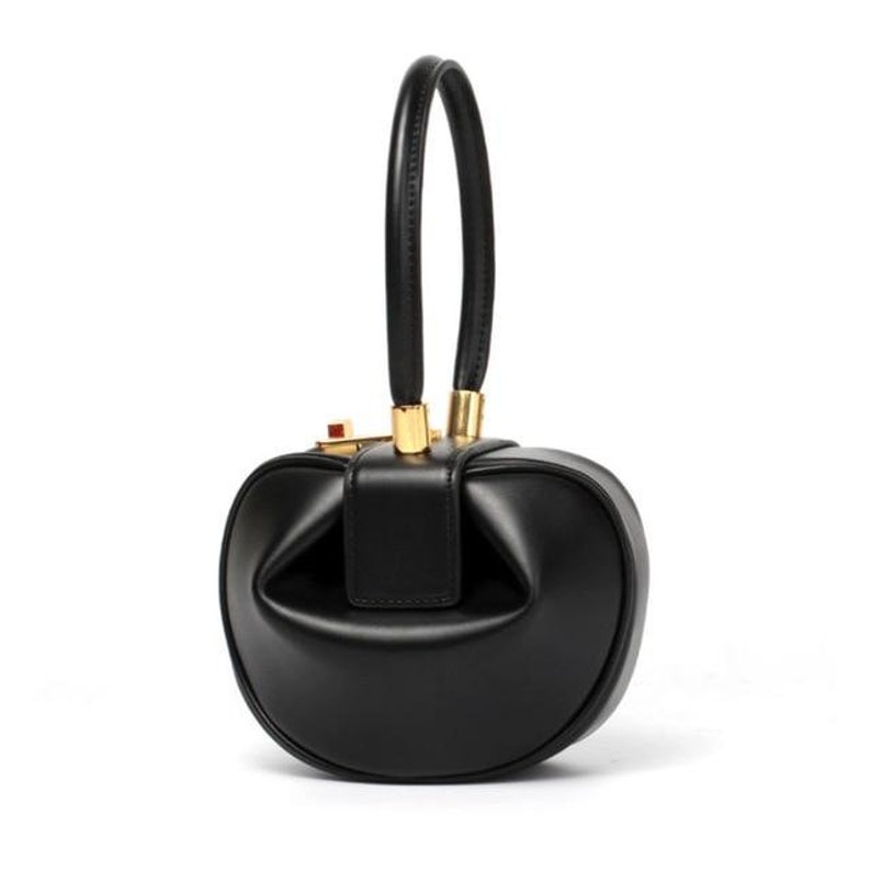 K&ouml;nnte beinhalten: Eine schwarze Ledertasche mit abgerundeter Form und einem goldenen Henkel.
