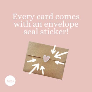 May include: A brown kraft paper envelope sealed with a small, light pink heart-shaped sticker. White arrows point toward the sticker. The text above reads: Every card comes with an envelope seal sticker! A white circular logo is in the bottom left.
