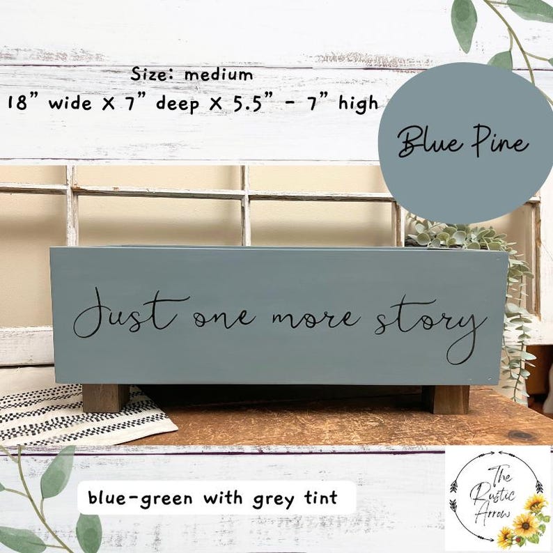 May include: A blue-green wooden planter box with the text "Just one more story" in black script. The planter is 18 inches wide, 7 inches deep, and 5.5 to 7 inches high. It has a blue pine color and sits on wooden feet.