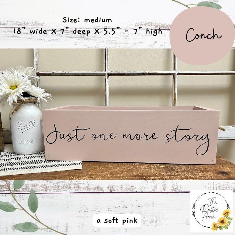 May include: A soft pink rectangular wooden box with the text "Just one more story" in black script. The box is 18 inches wide, 7 inches deep, and 5.5 to 7 inches high. A mason jar with white flowers is to the left.