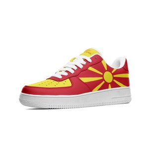May include: Red and yellow trainers with a stylised sun design on the side. The sun design is the flag of Macedonia.