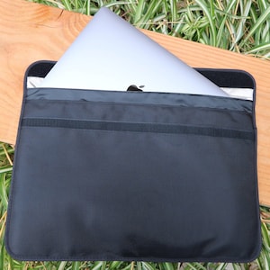 Puede incluir: Una funda para portátil negra con cierre de cremallera. La funda está hecha de un material duradero y tiene un forro suave para proteger tu portátil. La funda está diseñada para adaptarse a la mayoría de los portátiles de 13 pulgadas.