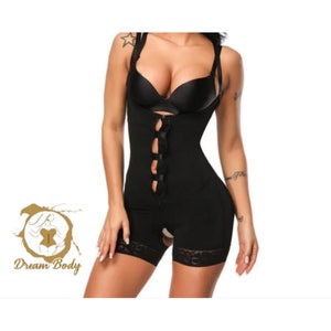 Könnte beinhalten: Schwarzer Body Shaper mit verstellbaren Trägern, einem Reißverschluss und Haken- und Ösenverschlüssen. Der Shaper hat einen Spitzenbesatz am unteren Rand.
