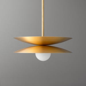 May include: A gold pendant light fixture with two circular, flat shades and a white globe light bulb.
