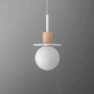 May include: A modern pendant light fixture with a white globe shade. The fixture features a natural wood accent, a white disc, and a white stem. The light hangs from a thin, neutral-colored cord, creating a minimalist design.